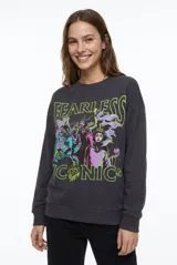 Buzo gris oscuro de frisa con cuello redondo, mangas largas y estampa frontal de villanas de Disney con el texto 'Fearless Iconic'.