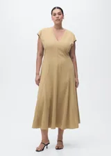 Vestido midi de manga corta en color beige, con cuello en V, diseño evasé, costuras decorativas visibles y cierre de cremallera en la parte posterior.