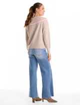 Buzo tejido de punto en color beige, con diseño nórdico geométrico en tonos rosa y blanco alrededor del canesú. Presenta cuello redondo a la base, mangas largas con puños elásticos y ruedo acanalado.