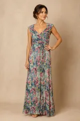 Vestido largo de gasa plisada con estampado floral en tonos celestes, rosas y verdes. Presenta un diseño con escote en V cruzado, drapeado en el busto y detalles de hilos plateados que aportan brillo a la prenda.