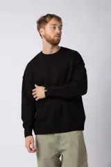 Sweater de punto grueso en color verde oliva, con diseño oversized, cuello redondo y mangas largas con puños acanalados.