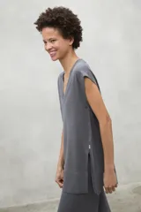 Chaleco de punto en lino color gris, con cuello en V, corte holgado y aberturas laterales en el ruedo.