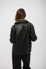 Campera de cuero sintético color negro, con cuello camisero, mangas largas y corte recto.