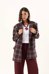 Blazer de corte oversize con estampado de cuadros en tonos azul, bordó y marrón. Presenta solapas clásicas, bolsillos con solapa en el frente y cierre frontal con botones.