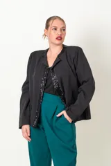 Chaqueta negra de crepe con solapas y borde frontal con lentejuelas. Corte recto y mangas largas.