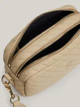 Bandolera Tommy Hilfiger color beige con diseño acolchado en diagonal y logo de la marca en dorado al frente.