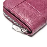 Billetera de tamaño compacto con cierre perimetral, confeccionada en material sintético con textura granulada. Presenta un diseño con costuras verticales y el logo metálico de la marca en la parte frontal.