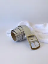 Cinto plateado de cuero con hebilla rectangular plateada.