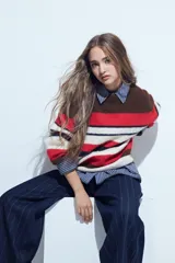 Sweater de tejido de punto con diseño de rayas horizontales en tonos rojo, blanco, azul marino y marrón. Presenta cuello redondo, mangas largas y un calce relajado.