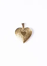 Dije relicario dorado con forma de corazón y grabado de flores.
