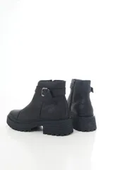 Botinetas de cuero negro con suela track y taco bajo. Presentan una correa decorativa con hebilla metálica alrededor del tobillo y cierre lateral interno.