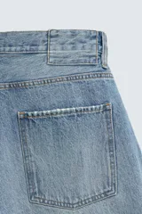 Jeans de hombre, corte balloon fit, tiro medio, confeccionados en denim rígido de algodón. Presentan un efecto lavado con un marcado degradado vertical, cinco bolsillos y cierre frontal con cremallera y botón.