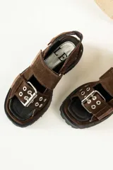 Sandalias negras de cuero con diseño de plataforma dentada, tiras ajustables con hebillas metálicas y detalle de tachas plateadas en el lateral de la suela.