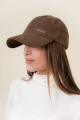 Gorra de diseño clásico con visera curva, confeccionada en material símil gamuza color bordó. Presenta un logo metálico con la palabra Peach en la parte frontal y cuenta con un sistema de ajuste posterior.