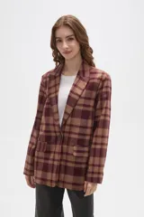 Blazer de corte holgado con diseño a cuadros en tonos marrones y negros. Presenta cuello con solapa, cierre frontal con un botón y bolsillos laterales con solapa.