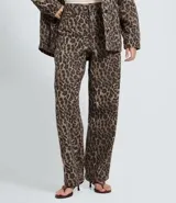 Pantalón baggy de sarga con estampado animal print, corte holgado y cintura mediana. Cuenta con bolsillos funcionales, trabillas para cinturón y cierre frontal con botón y cremallera.