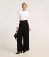 Pantalón pantalona de sastrería color negro, de cintura alta con diseño cruzado y hebillas laterales.