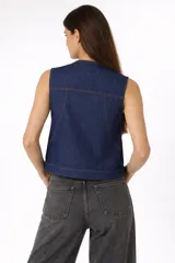 Chaleco de denim azul oscuro con cierre frontal y lazo para anudar. Presenta bolsillos frontales tipo cargo y costuras a la vista en contraste.