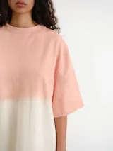 Remerón de corte oversize con diseño bicolor en tonos rosado y blanco hueso, de manga corta y cuello redondo.