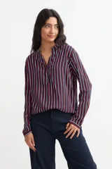Blusa de viscosa con estampado de rayas verticales en azul marino, rojo y blanco, con cuello mao y mangas largas con puños abotonados.