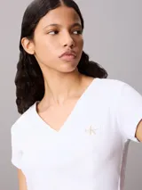 Remera de corte slim confeccionada en punto de algodón elástico con textura fina de canalé. Presenta cuello en V, manga corta y una insignia con el logo de Calvin Klein en el pecho.