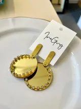 Aros colgantes dorados con forma circular y borde de strass.