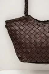 Cartera de cuero marrón con diseño trenzado y asas de hombro trenzadas.