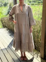 Vestido largo color verde oliva, de lino, con corte amplio, cuello mao, escote en V y mangas largas acampanadas.