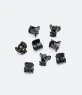 Set de ocho mini pinzas negras de plástico para el pelo, con diseño rayado.