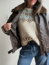 Campera estilo bomber de efecto cuero en color chocolate, con cuello de pelo sintético desmontable, cierre frontal, bolsillos laterales amplios y cintura elástica con ajuste lateral.
