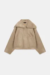 Cazadora bomber de efecto ante en color beige, con cuello de solapa amplio, cierre frontal con cremallera y bolsillos delanteros.
