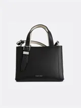 Cartera tipo tote de tamaño compacto, confeccionada en piel sintética lisa color negro. Presenta doble asa de mano ajustable con detalle de hebilla metálica y correa larga ajustable. Incluye cierre principal con cremallera y logo de la marca grabado en la parte inferior frontal.