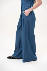 Pantalón azul de corte wide leg, con cintura elástica ajustable mediante cordón y bolsillos laterales.