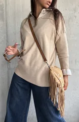 Sweater de punto en color beige, con cuello redondo, mangas largas con puños acanalados y diseño de corte holgado.