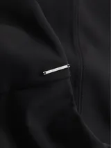 Vestido negro de corte ajustado, con largo a la rodilla, mangas cortas y cuello redondo. Presenta un cierre de cremallera en la parte posterior y recortes en los hombros.