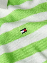 Chomba de punto a rayas horizontales verdes y blancas, con cuello polo blanco, cartera de cuatro botones y logo bordado de Tommy Hilfiger en el pecho.