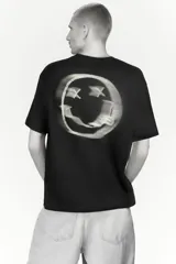 Remera de algodón color negro con cuello redondo y mangas cortas. Presenta un estampado frontal con el logo de la banda Nirvana en color amarillo y una imagen en blanco y negro del concierto Live at Reading.