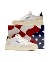 Championes de cuero blanco con detalles en gamuza beige y refuerzo en el talón color negro. Presentan cordones al tono, suela de goma color crema y logo de la marca con bandera estadounidense en el lateral.