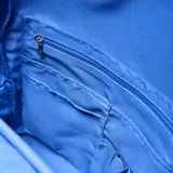 Mochila de tela arrugada color azul, con múltiples compartimentos con cierre, bolsillos laterales y logo circular grabado en el frente.