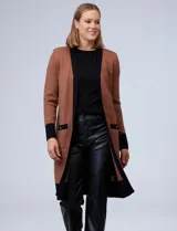 Cardigan largo tejido color marrón con ribetes negros en contraste, bolsillos delanteros y mangas largas.