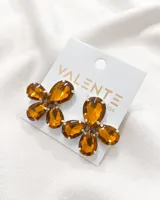 Aros colgantes con forma de flor, compuestos por cinco cristales color ámbar engarzados en metal plateado.