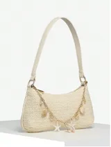 Cartera de mano color beige, tejida en rafia, con cadena dorada y apliques de dijes con forma de estrellas de mar, caracoles y perlas.