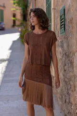 Falda marrón tejida en lurex con largos flecos, calce al cuerpo y forro al tono.