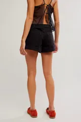 Short de denim negro de tiro medio y calce entallado, con cierre de botones a la vista, cinco bolsillos y ruedo con dobladillo vuelto.