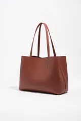 Bolso shopper Bimba Y Lola color marrón, de tamaño grande con exterior de piel vacuna. Presenta doble asa de hombro, cierre con botón de presión y logo grabado en letras doradas en la parte frontal.