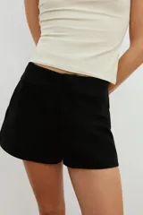 Bermudas de tiro medio color marrón con bolsillos en delantero y falsos bolsillos con solapa en espalda, de corte estructurado y cierre frontal con cremallera y ganchos metálicos.