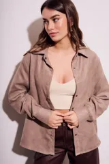 Camisa color marrón claro de gamuza vegana, corte oversize, con cuello clásico, cierre frontal con botones y mangas largas.