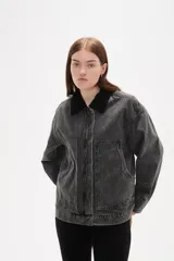 Campera de jean con lavado gris desgastado, cuello camisero en pana negra, cierre frontal con botones y bolsillos laterales amplios.