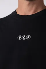Remera de corte boxy y fit cuadrado, confeccionada en algodón grueso de alta calidad. Presenta un diseño minimalista en el frente con un pequeño logo circular y una estampa de gran tamaño en la espalda con la frase 'Designed in South America, Worldwide Clothes'.