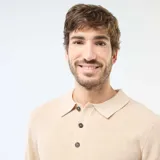 Sweater de punto con textura gofrada, color beige, con cuello polo y cierre frontal de tres botones. De manga larga y corte estándar.